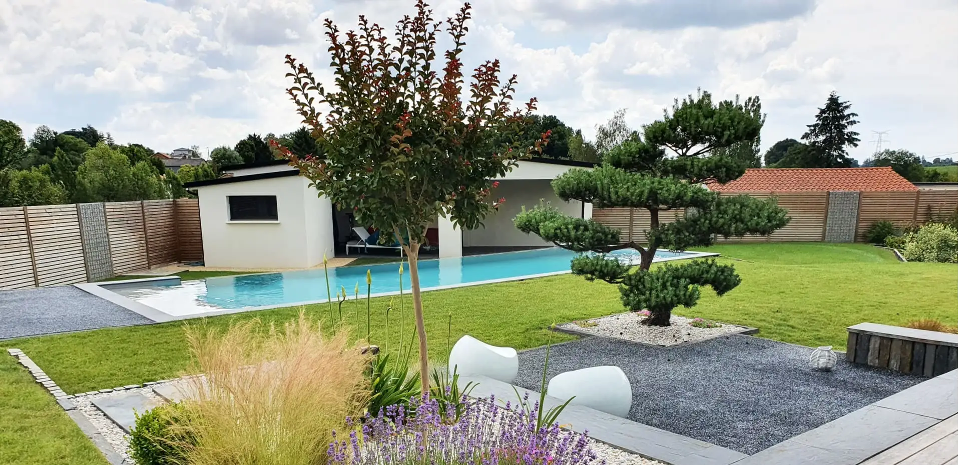 Création d'espaces autour de la piscine : terrasse en bois, pavage, murets, dallage, gazon...